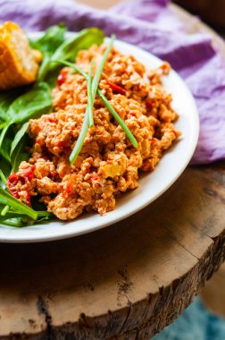 Çırpılmış vejetaryen yumurtası, yeşil ve mısır renginde. Düz, üst manzaralı. Menekşe, çiçek dekorasyonu.