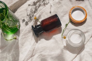 Sürdürülebilirlik konsepti kozmetik arka plan kahverengi cam çiçekler papatya örtüsü ve düz ürün yeşil güzellik blog konsepti yatıyordu