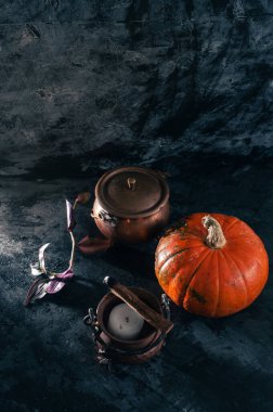 Bir balkabağı kabağı ve bakır veya mum ve palo santo incence ile pirinç cadı tenceresi koyu mavi desenli kopya alanı arkaplan Cadılar Bayramı Cadılar Bayramı kavramı cadı sihirli karanlık karamsar çekim