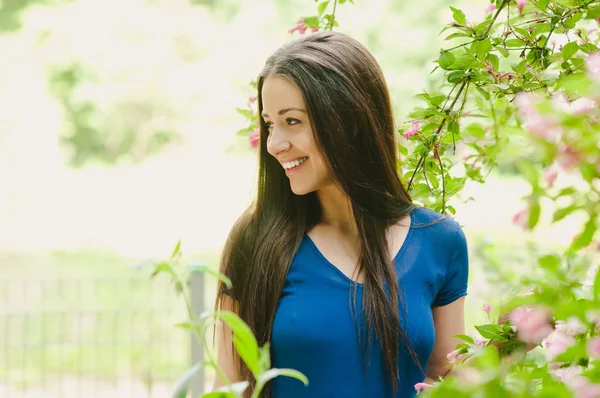 Beautiful happy young woman smiling at flower background