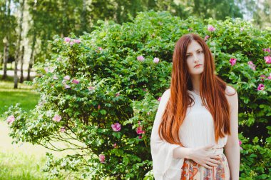 Summer sunny portrait of a ginger girl looking at camera