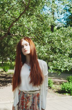 Beautiful young ginger girl sunny summer portrait