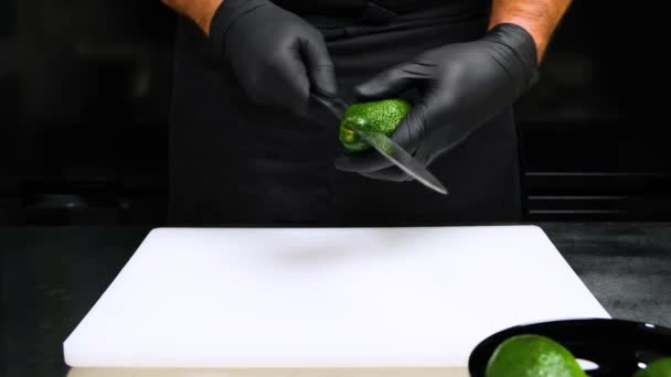 Zblízka pohled mužské ruce odříznout avokádo peeling. samčí vařič peeling avokádo kůže. — Stock video