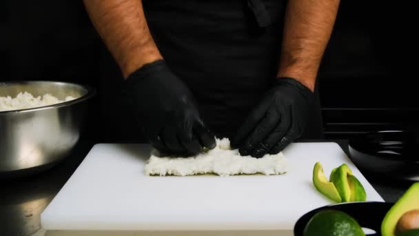 寿司大厨在诺里纸上撒日式寿司饭，调味寿司卷. — 图库视频影像
