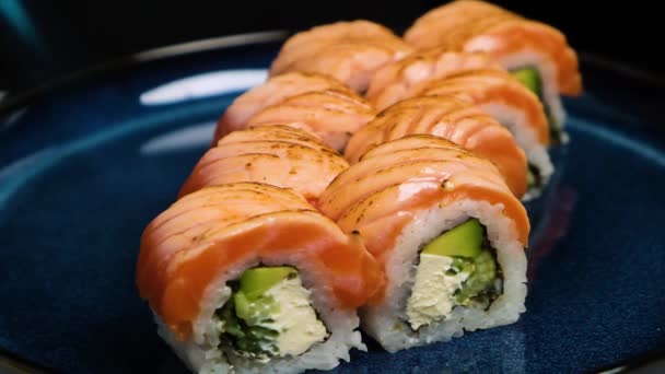 Närbild av professionell kock hand bränna lax sushi rulle med räkor tempura och majonnäs på servering tallrik. Chef förbereder hälsosam sushi meny på öppet kök diskbänk i japansk restaurang. — Stockvideo
