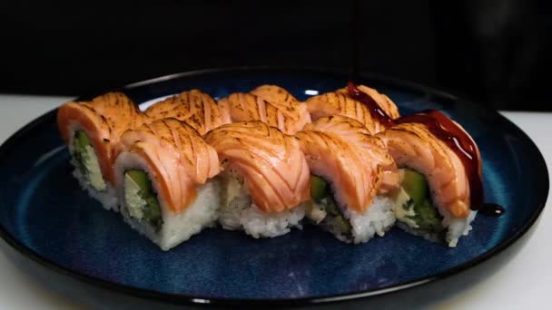 Rotoli di sushi su strumento piatto scuro versando salsa sul sushi incredibile cibo giapponese — Video Stock