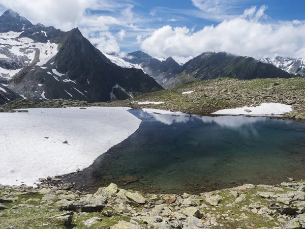 Όμορφη παγωμένη λίμνη με πηγές από λιώσιμο παγετώνα με αιχμηρές χιονισμένες βουνοκορφές που αντανακλούν στην επιφάνεια του νερού. Tyrol, Stubai Alps, Αυστρία, ηλιόλουστη μέρα του καλοκαιριού — Φωτογραφία Αρχείου