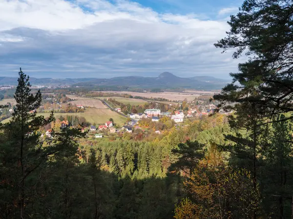 Vista da Hrabencina vyhlidka belvedere sul villaggio Sloup v cechach in luzicke hory, Montagne Lusaziane con autunno colorato foresta di latifoglie e conifere e verdi colline, cielo blu, nuvole bianche — Foto Stock