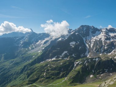 Stubai yürüyüş parkurunda dolambaçlı bahar akıntısı olan karlı dağların ve yeşil vadinin manzarası, Stubai Hohenweg, Tyrol, Stubai Alps, Avusturya Alp. Yaz masmavi gökyüzü