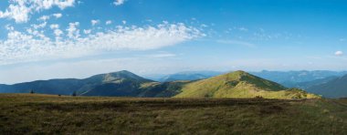 Çimenli yeşil tepelerin geniş manzarası ve alçak Tatras dağlarının yamaçlarında yürüyüş patikaları, dağ çayırları ve çam çalıları, Slovakya, yaz güneşli günü, mavi gökyüzü arka planı