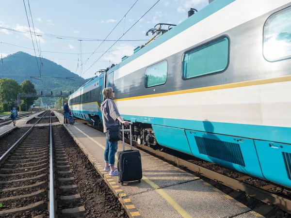 Ружомберок, Словакия, 30 августа 2020 года: международный поезд прибыл на железнодорожную платформу с группой ожидающих на центральном железнодорожном вокзале в Ружомберок, летний солнечный день — стоковое фото