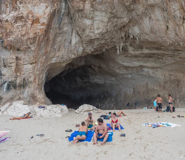 Cala Gonone, Sardaigne, Italie, 8 septembre 2020 : Groupe de touristes bronzant et prenant des photos devant la grotte à Cala Luna plage de sable. Destination touristique célèbre — Photo