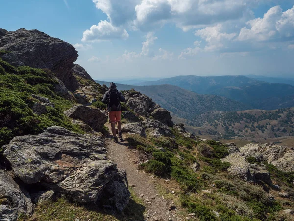 Caminante solitario en la montaña Gennargentu, la montaña más alta de Cerdeña, Nuoro, Italia. Vastos picos, llanuras secas y valles con vegetación mediterránea. A finales del verano, cielo azul — Foto de Stock