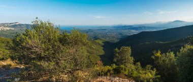 Geniş panoramik yeşil manzaralı Arbatax pelerin kireç taşı kayaları, Akdeniz, tarlalar ve yemyeşil bitki örtüsü. Ogliastra, Sardinya, İtalya. Yaz masmavi gökyüzü