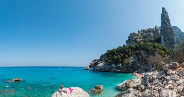 Orosei Körfezi, Sardunya, İtalya, 17 Eylül 2020: Cala Goloritze plajının turistik manzarası, kireçtaşı kaya sütunu Aguglia, doğal kemer ve turkuaz mavi su