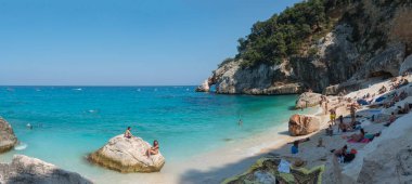 Orosei Körfezi, Sardunya, İtalya, 17 Eylül 2020: Turist halkı, kireçtaşı doğal kemer ve turkuaz mavi su ile Cala Goloritze plajının panoramik manzarası. Meşhur seyahat yeri