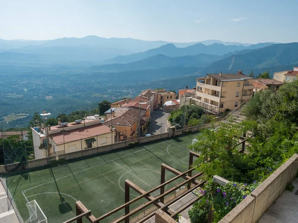 Baunei, Cerdeña, Italia, 19 de septiembre de 2020: Vista del campo de fútbol en la terraza del antiguo pueblo romántico Baunei con vista al valle verde y las montañas Supramonte. — Foto de Stock