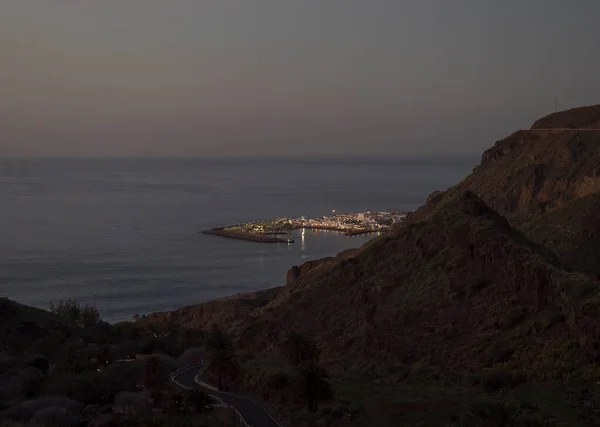 Vue de nuit d'heure bleue de Puerto de las Nieves, lumières traditionnelles de port de village de pêcheurs avec falaises et rochers et route sinueuse dans le nord-ouest de Gran Canaria, îles Canaries, Espagne. — Photo