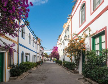 Puerto de Mogan, Gran Canaria, Kanarya Adaları, İspanya 18 Aralık 2020: Küçük balıkçı köyü limanı Puerto de Mogan 'ın yaya yolundaki geleneksel renkli evler.