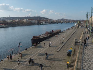 Prag, Çek Cumhuriyeti, 26 Mart 2021: Vltava nehrinin seti, güneşli bahar günlerinde Covid salgını sırasında kalabalıkla birlikte Naplavka olarak adlandırıldı. Arka planda Palacky Köprüsü ve Prag
