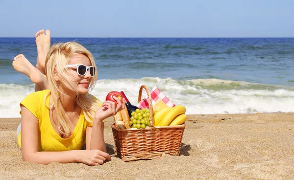 Picknick am Strand. blonde junge Frau mit Korb mit Lebensmitteln auf t — Stockfoto