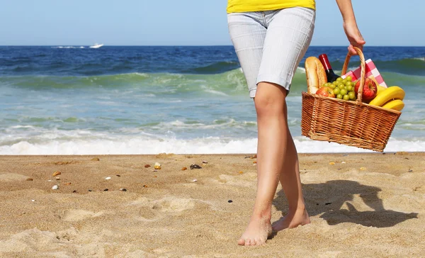 Picknick am Strand. weibliche Beine und Korb mit Futter auf der — Stockfoto