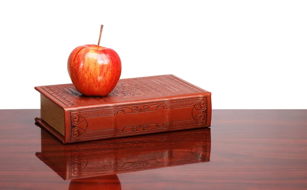 Libros y manzana en el escritorio, aislados en blanco — Foto de Stock