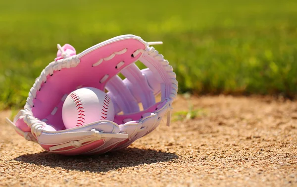 Béisbol en guante femenino rosa en el campo —  Fotos de Stock