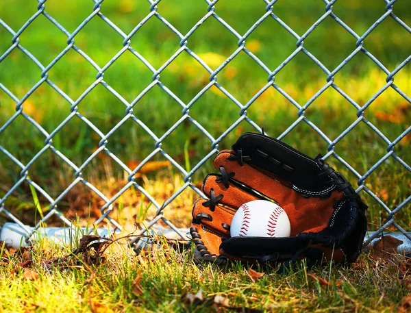 Honkbal in handschoen op groen gras — Stockfoto