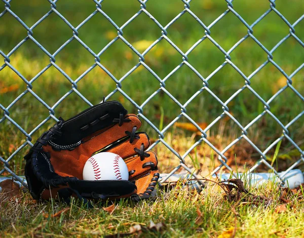 Honkbal in handschoen op groen gras — Stockfoto