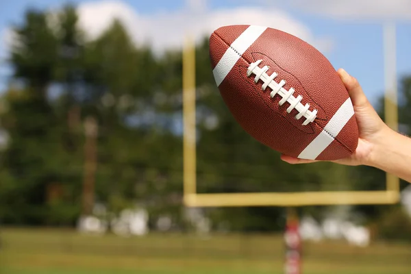 American Football in Hand over Field with Goal Post or Uprights — Stock Photo, Image