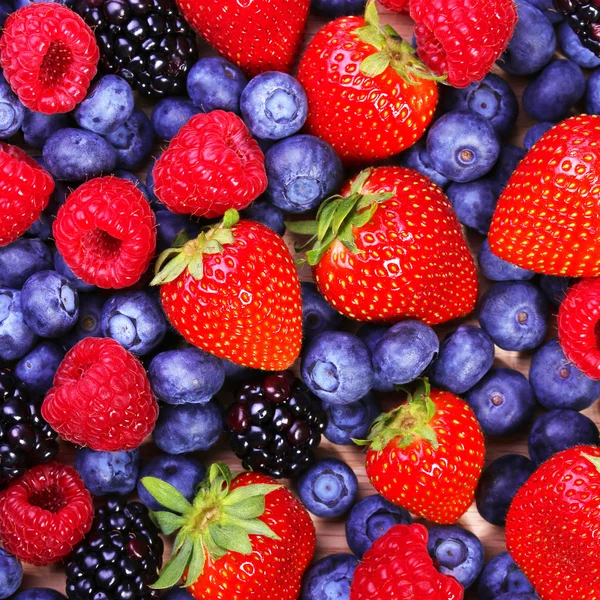 Beeren im Hintergrund. Erdbeeren, Blaubeeren, Himbeeren und Birnen — Stockfoto