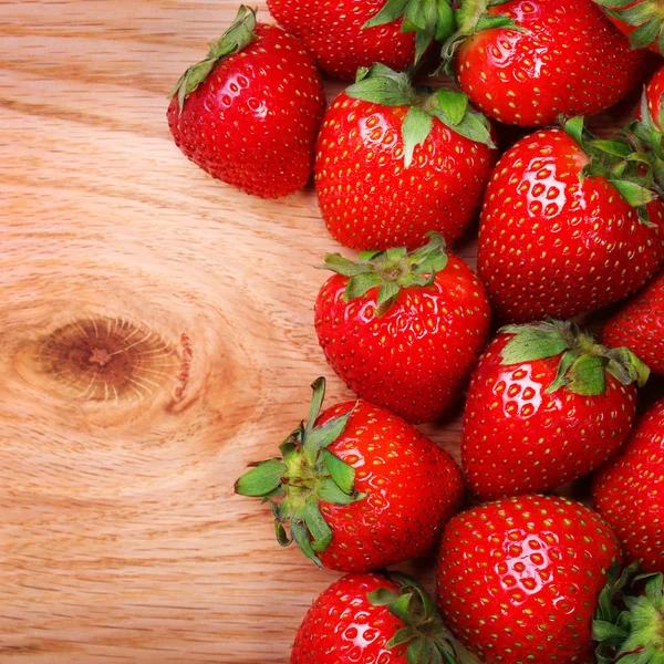 Fresas sobre fondo de madera — Foto de Stock