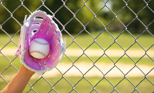 Mano del giocatore di baseball con guanto rosa e palla sul campo — Foto Stock