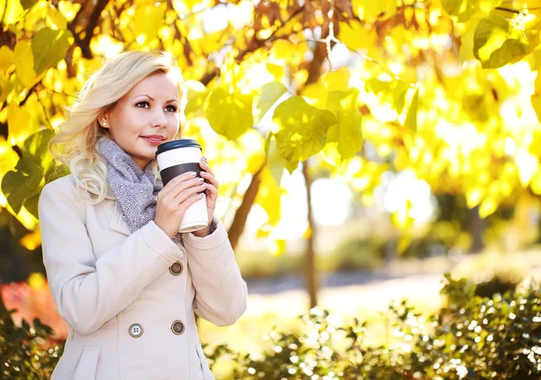 Осенняя женщина с кофейной чашкой. Падение. Блондинка-девочка — стоковое фото