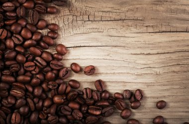 Kahve çekirdekleri ahşap arka planda.