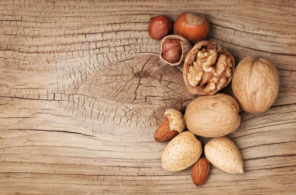 Frutta a guscio su vecchio sfondo di legno. Nocciole, mandorle e noci — Foto Stock