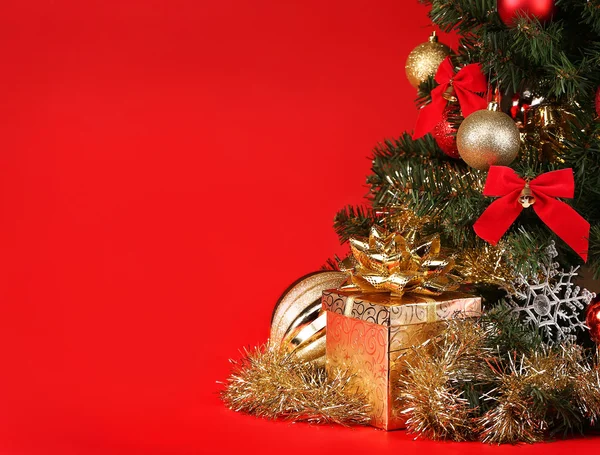 Navidad. Caja de regalo bajo el árbol de Navidad sobre fondo rojo —  Fotos de Stock