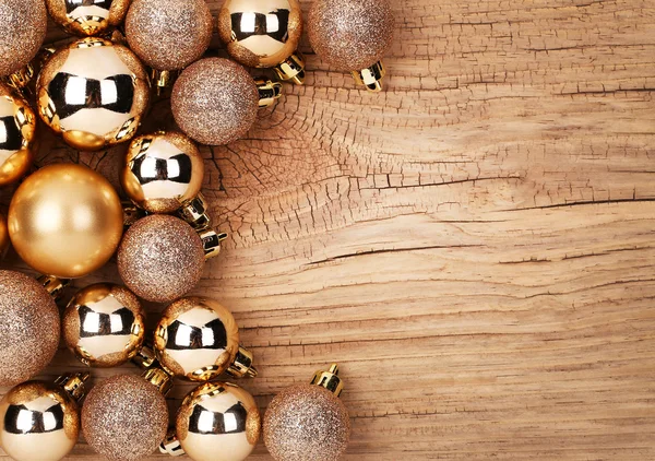 Goldene Weihnachtskugeln über Holzgrund — Stockfoto