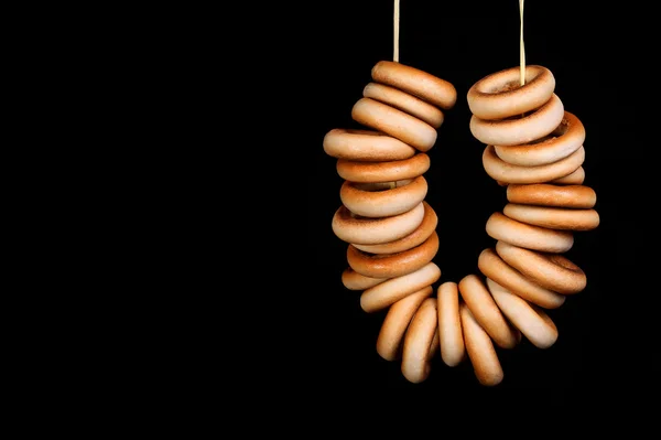 Bagels na corda sobre fundo preto — Fotografia de Stock