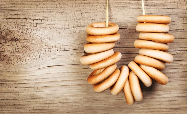 Bagels on rope over wooden background — Stock Photo, Image