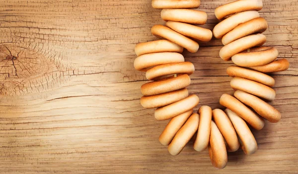 Bagels on rope over wooden background — Stock Photo, Image