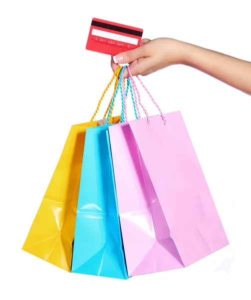 Bolsas de compras coloridas y tarjeta de crédito en mano femenina aislada — Foto de Stock