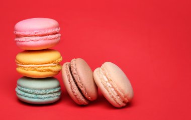 Kırmızı bir arka plan üzerinde renkli Fransızca Macarons