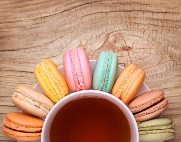 Barevná francouzská Macarons šálku čaje na dřevěné pozadí. T — Stock fotografie