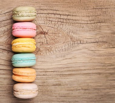 Ahşap arka plan üzerinde renkli Fransızca Macarons