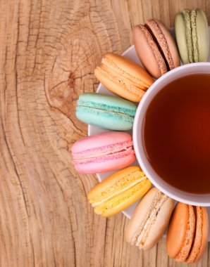 Çay Kupası ahşap arka plan üzerinde renkli Fransızca Macarons. T