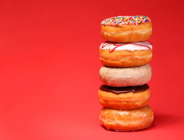 Sweet donuts on red background — Stock Photo, Image