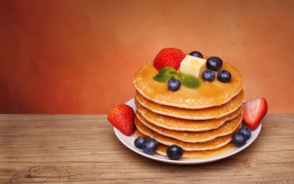 Tumpukan pancake dengan blueberry segar, strawberry dan maple syr — Stok Foto