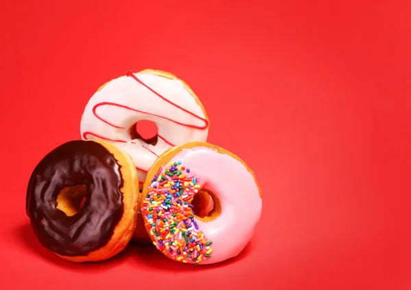 Doce donuts no fundo vermelho — Fotografia de Stock